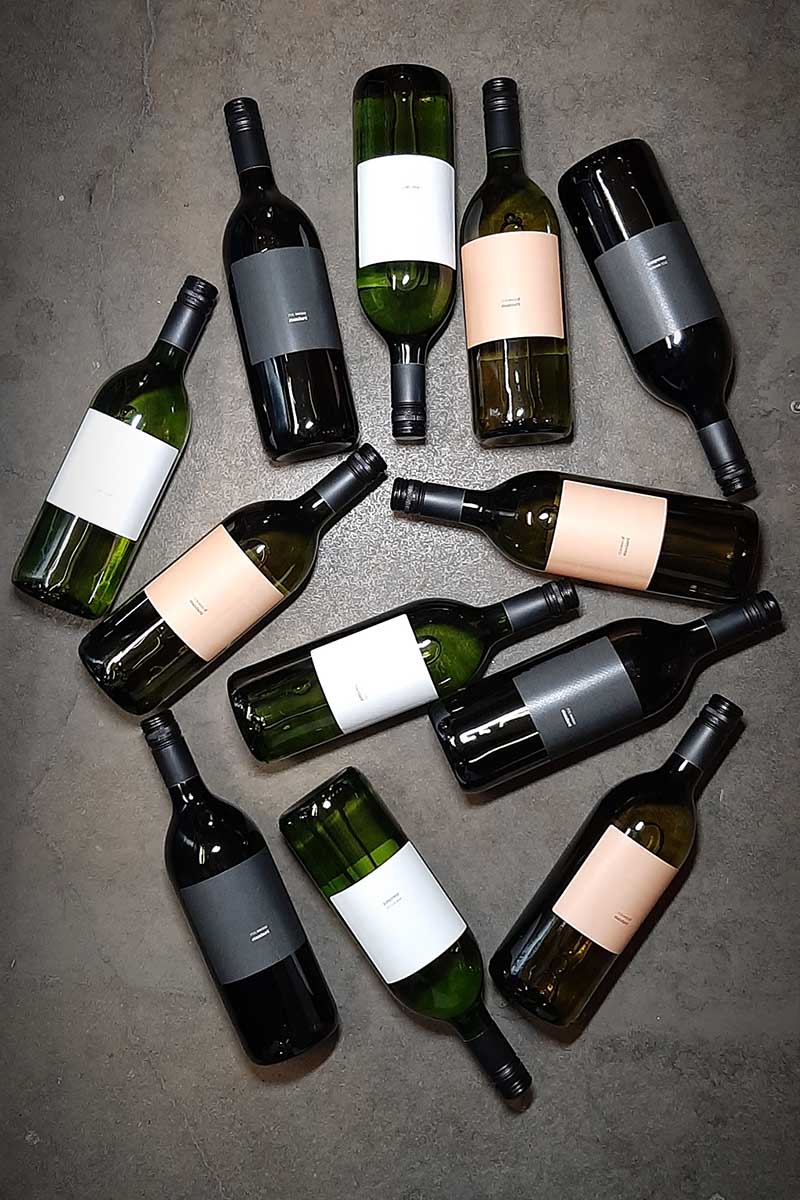 Ein Bild alle drei Standards, weiss rosé und rot, auf Beton.